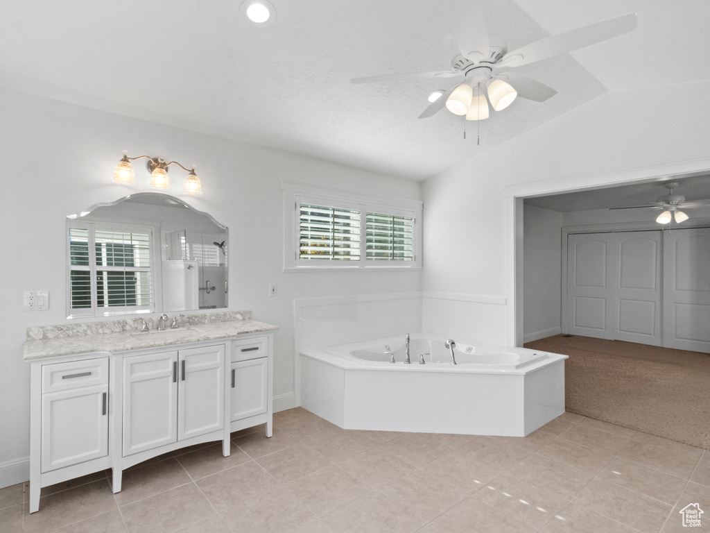 Bathroom featuring vanity, a bath, tile flooring, vaulted ceiling, and ceiling fan