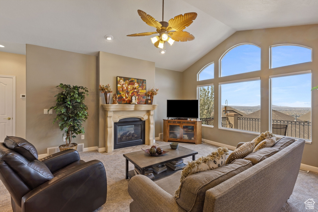 Living room with light colored carpet, ceiling fan, and high vaulted ceiling