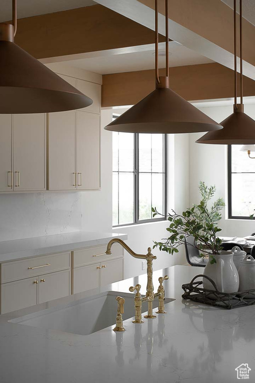 Kitchen with light stone countertops and white cabinetry