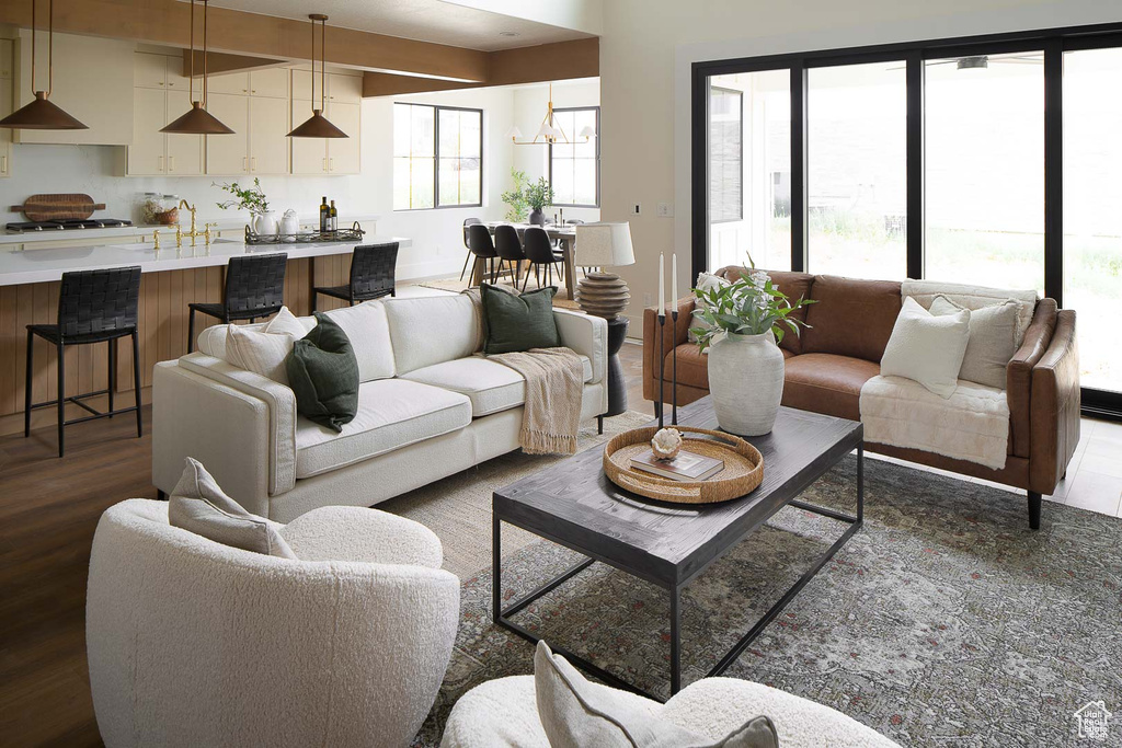 Living room featuring dark hardwood / wood-style floors, sink, and an inviting chandelier