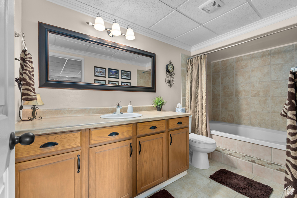Full bathroom with shower / tub combo, a drop ceiling, oversized vanity, tile flooring, and toilet