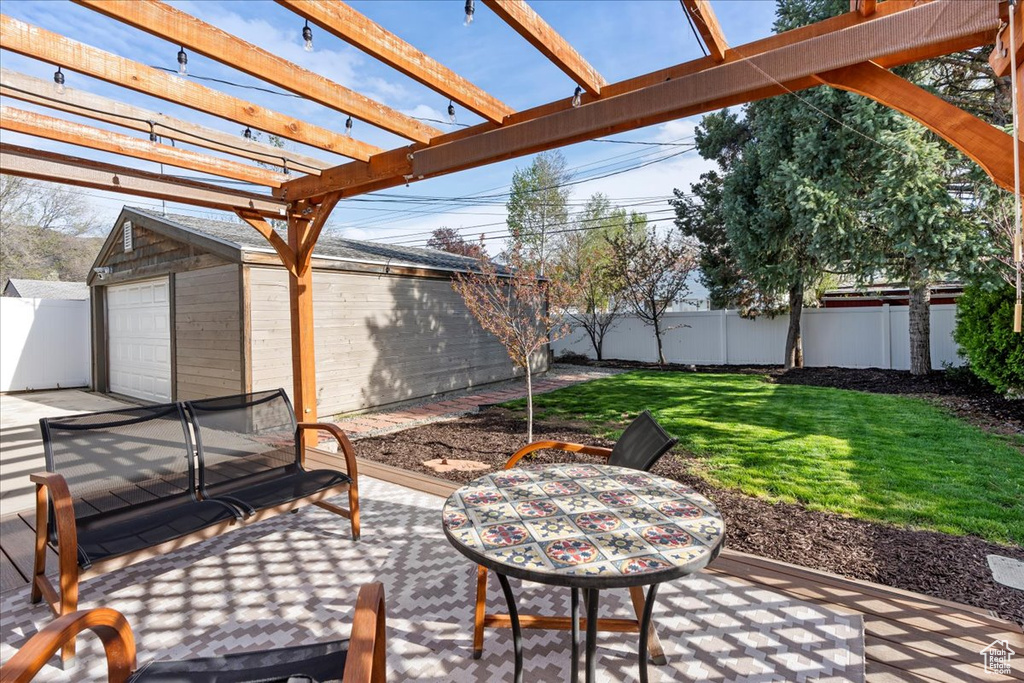 View of patio featuring an outdoor structure, a pergola, and a garage