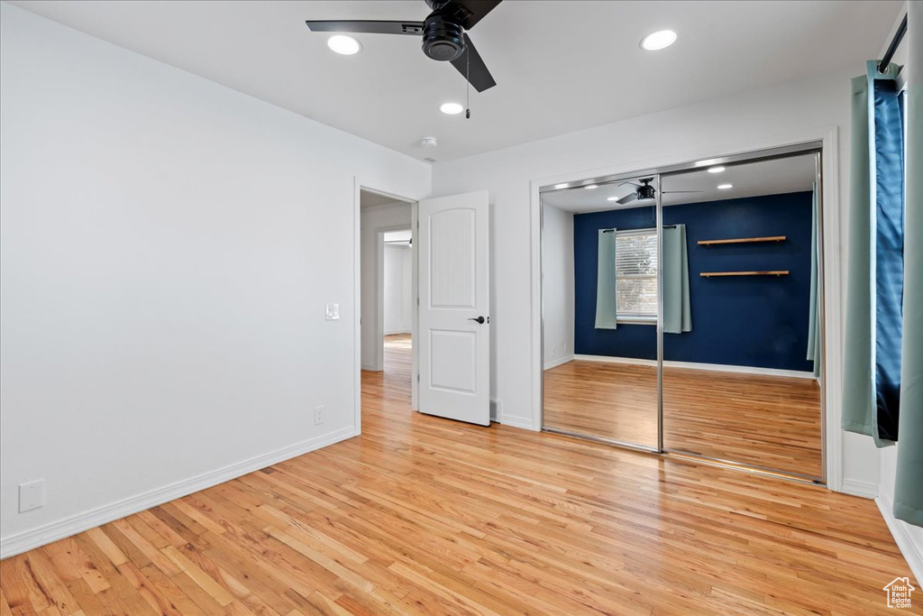 Unfurnished bedroom with a closet, ceiling fan, and light wood-type flooring