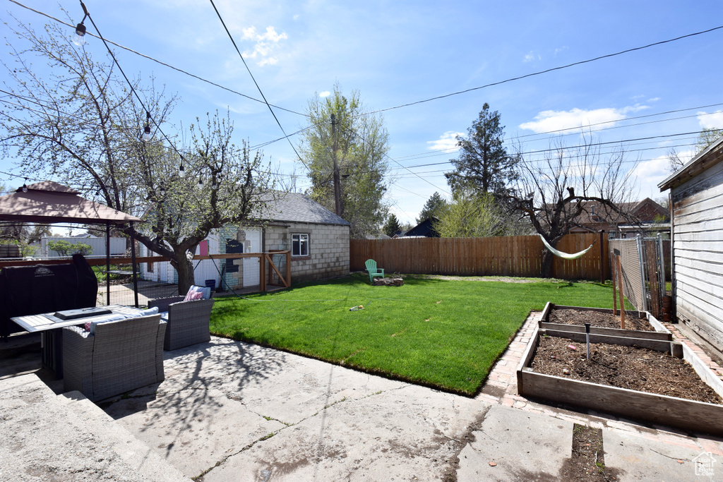 View of yard featuring a patio area, an outdoor structure, and a gazebo