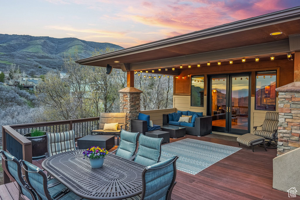 Deck at dusk with a mountain view and an outdoor hangout area