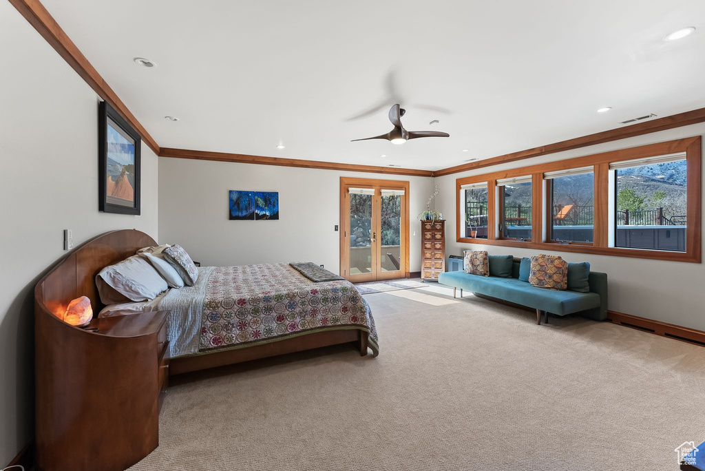 Bedroom featuring crown molding, light colored carpet, and ceiling fan