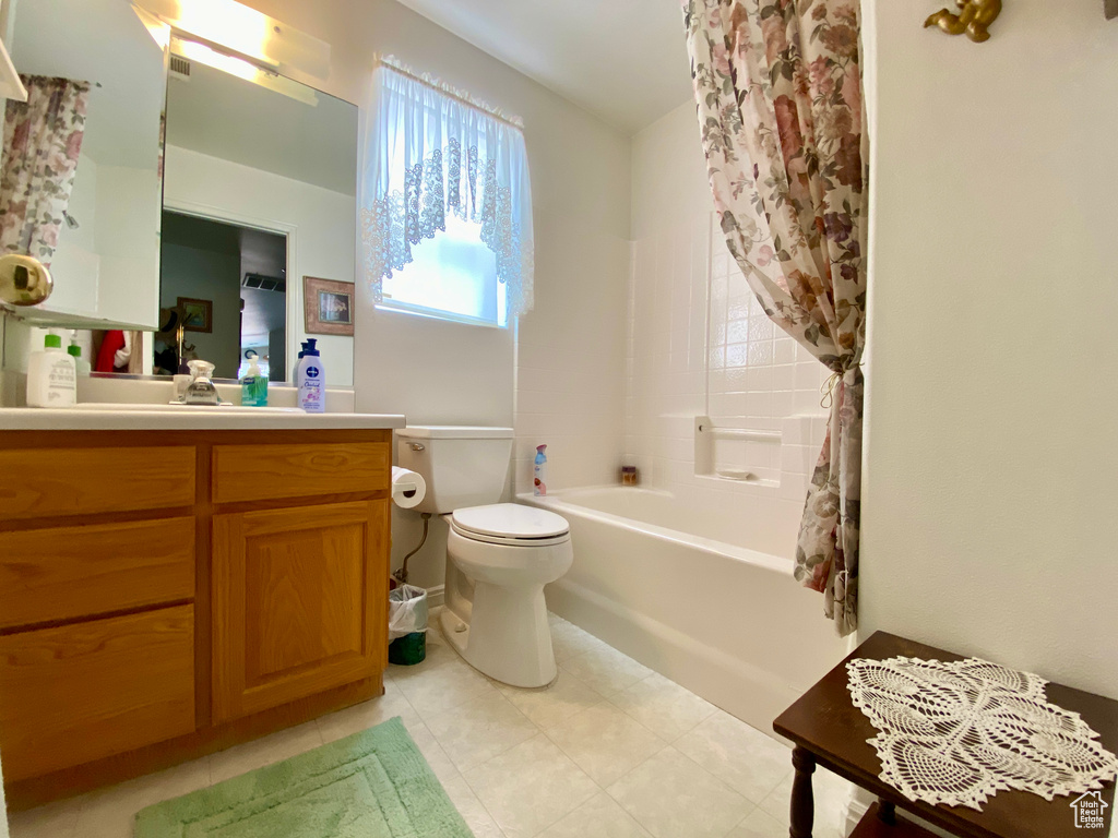 Full bathroom with vanity, toilet, tile floors, and shower / bath combination with curtain