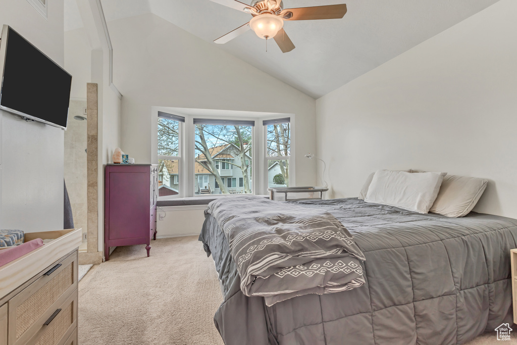 Bedroom with high vaulted ceiling, ceiling fan, and light carpet