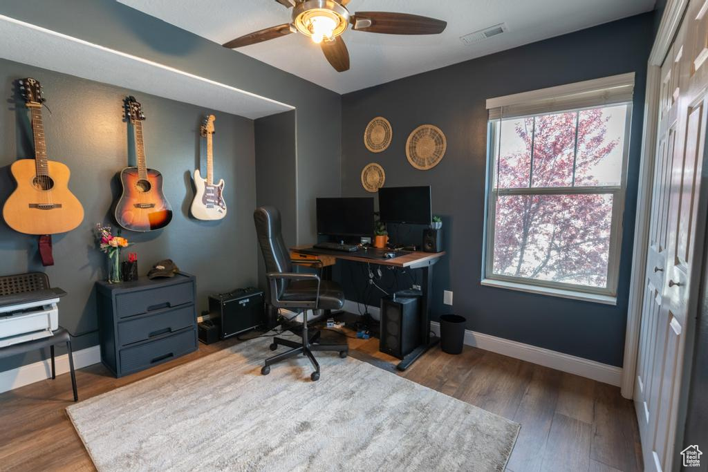Home office featuring dark hardwood / wood-style flooring and ceiling fan