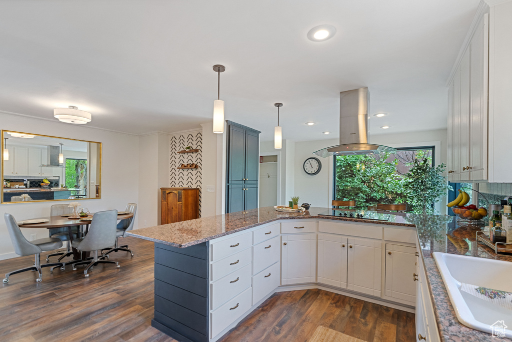 Kitchen featuring island range hood, wall chimney exhaust hood, light stone counters, sink, and dark hardwood / wood-style flooring