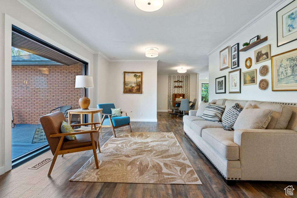 Living room featuring brick wall, crown molding, and dark hardwood / wood-style floors