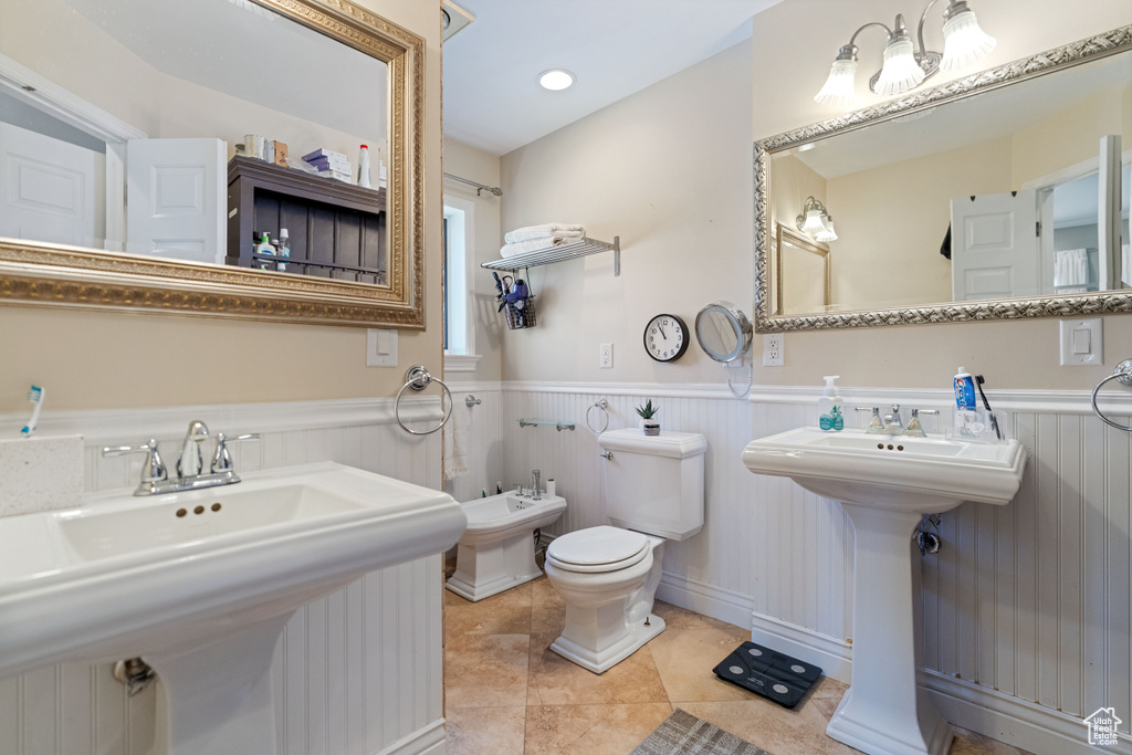 Bathroom with a bidet, toilet, tile flooring, and sink