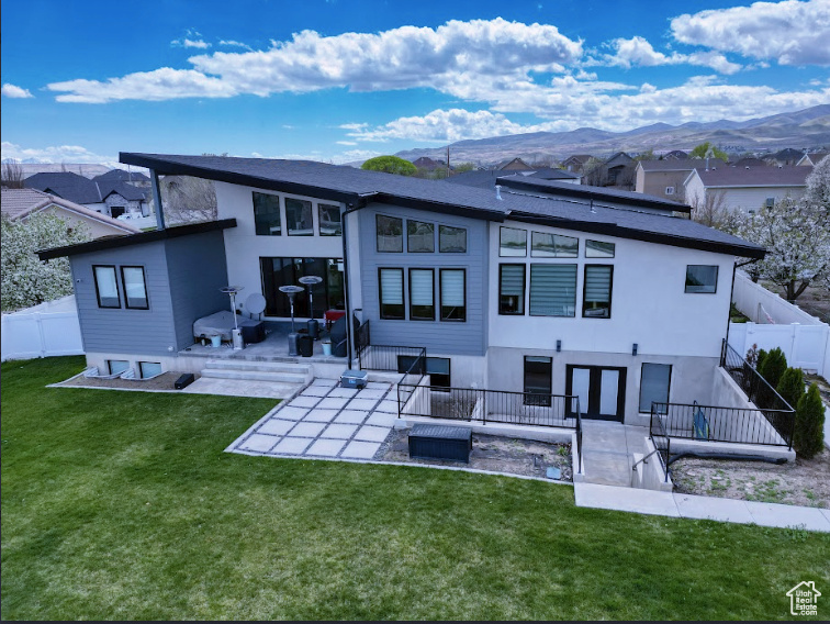 Back of property featuring a patio, a yard, a mountain view, and outdoor lounge area