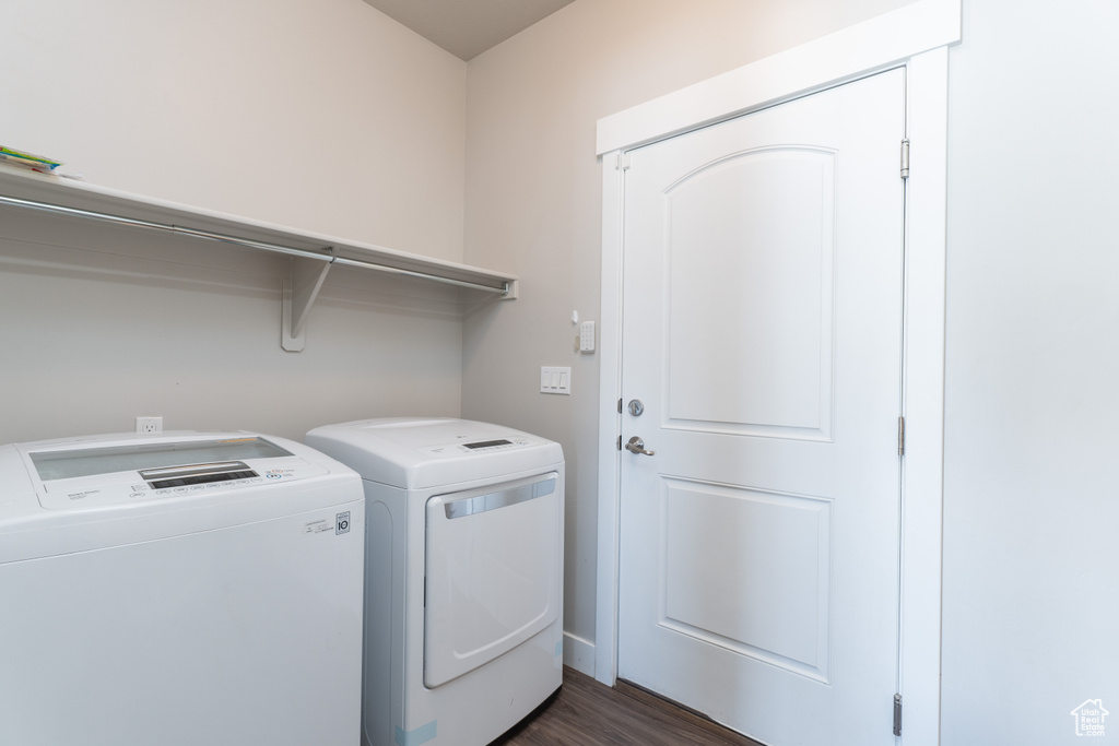 Laundry area featuring dark wood-type flooring and washer and clothes dryer