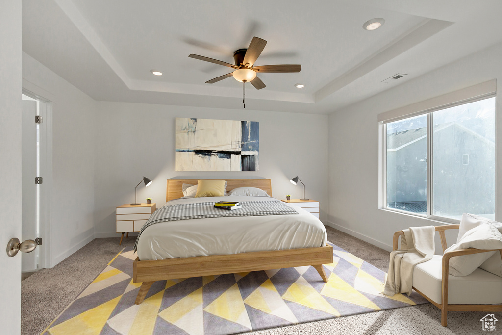 Bedroom with ceiling fan, carpet flooring, and a tray ceiling