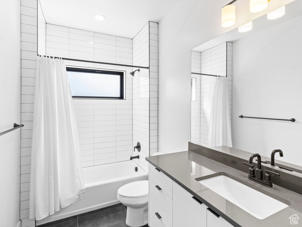 Full bathroom with vanity, toilet, tile floors, and shower / bath combo with shower curtain