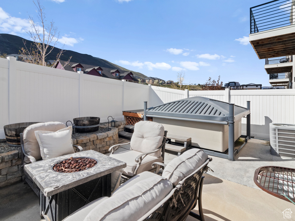 View of patio / terrace featuring a fire pit, a mountain view, and central air condition unit