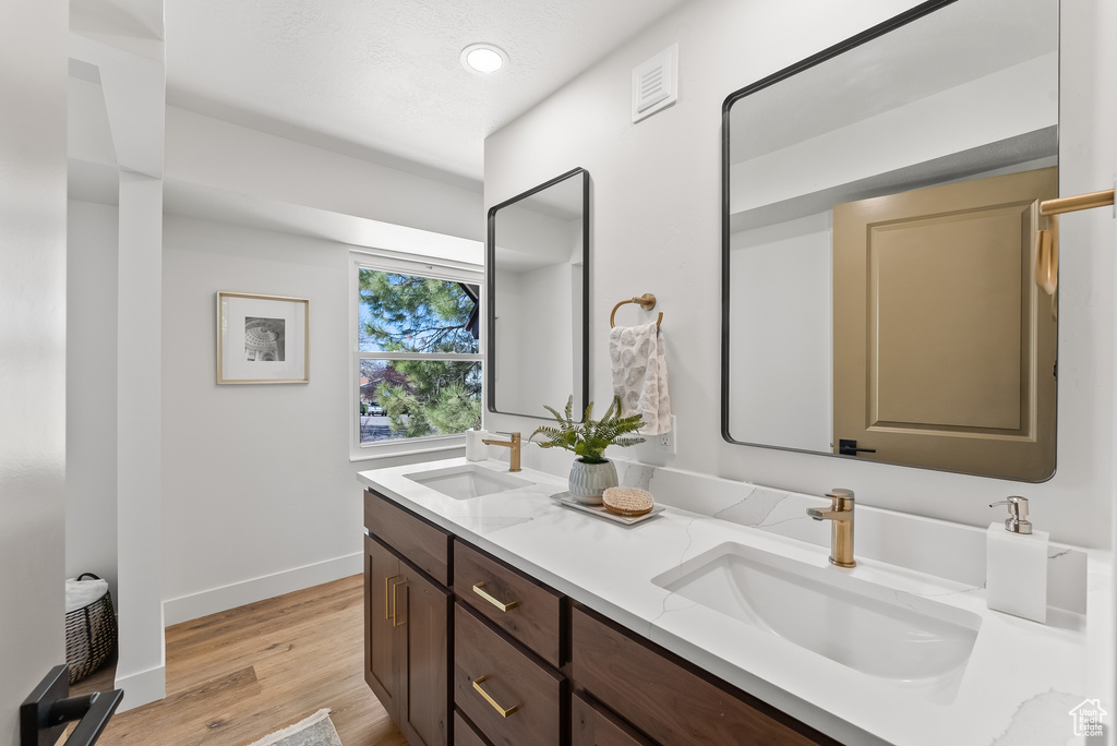 Bathroom with hardwood / wood-style flooring and dual vanity