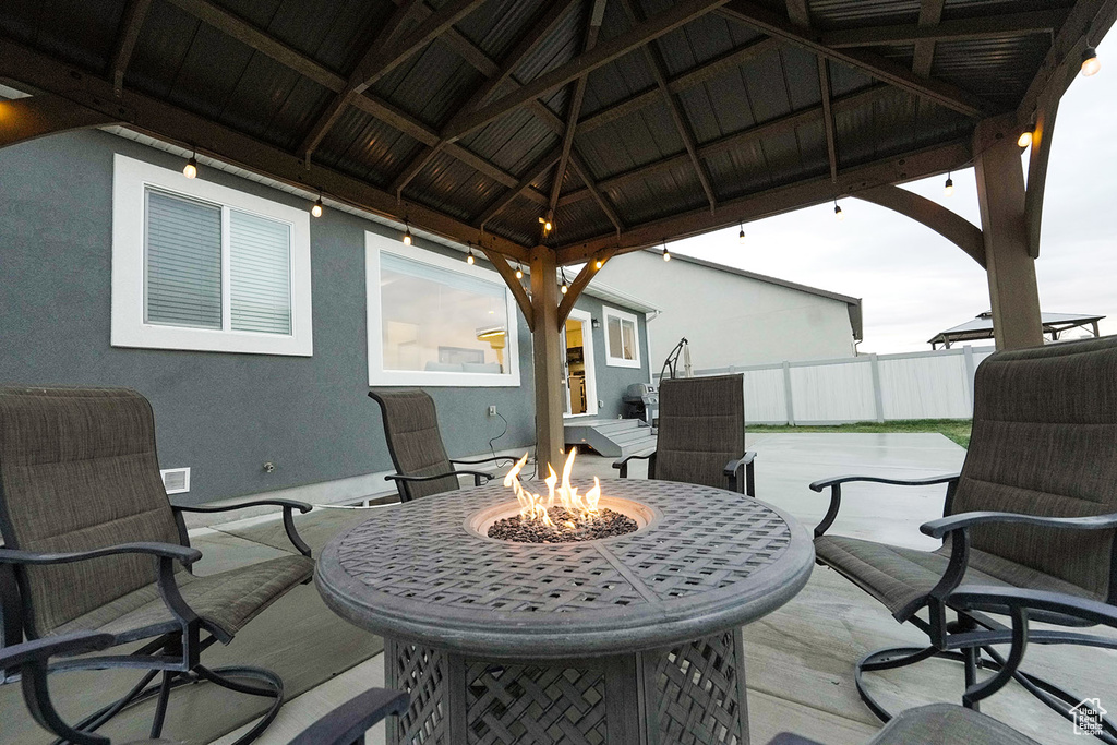 View of terrace featuring a fire pit and a gazebo