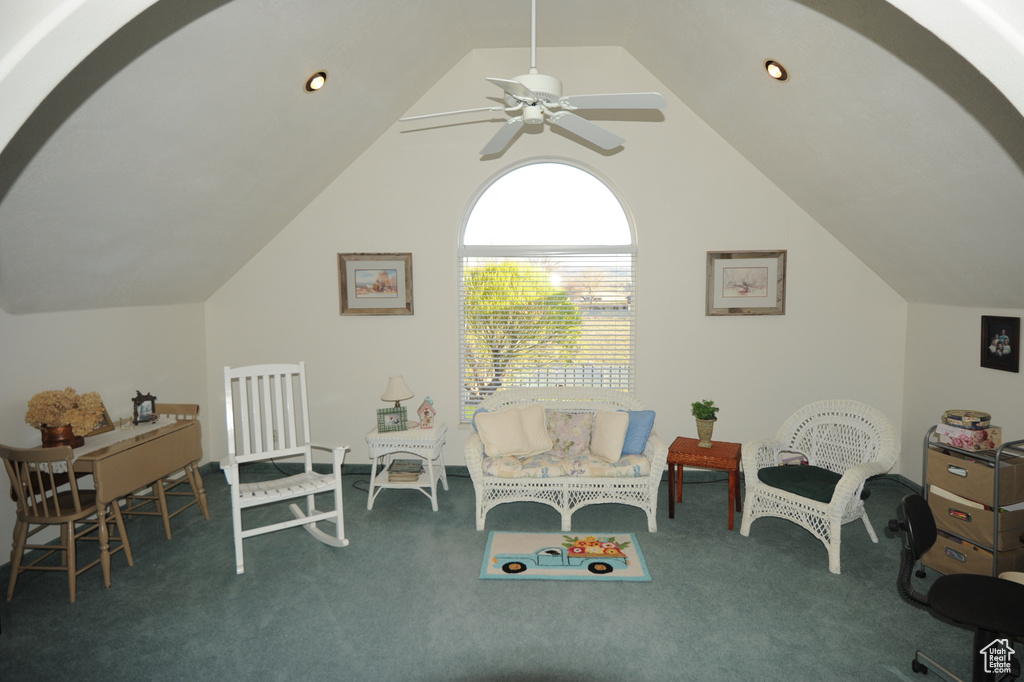Interior space featuring vaulted ceiling, ceiling fan, and dark colored carpet