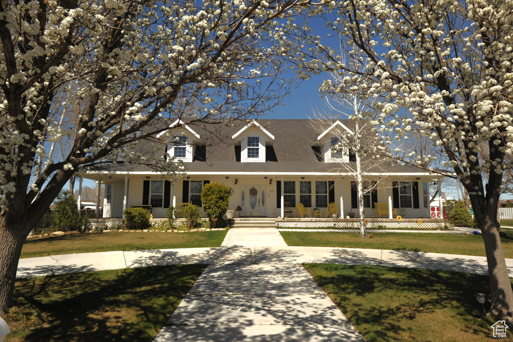 View of front of house featuring a front lawn and a porch