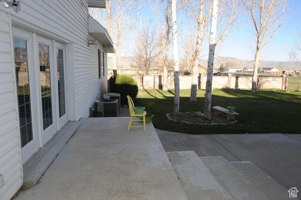 View of yard featuring a mountain view, central AC unit, and a patio