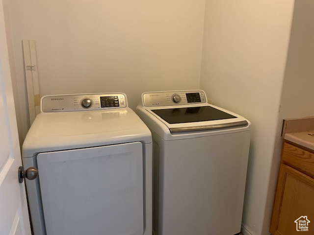 Washroom featuring washing machine and dryer and cabinets