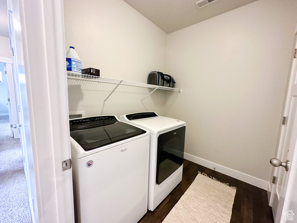 Laundry area featuring independent washer and dryer and dark colored carpet