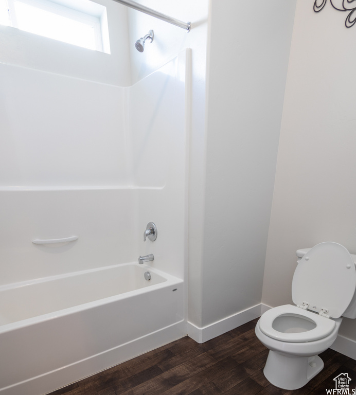 Bathroom featuring hardwood / wood-style flooring, toilet, and shower / bathing tub combination