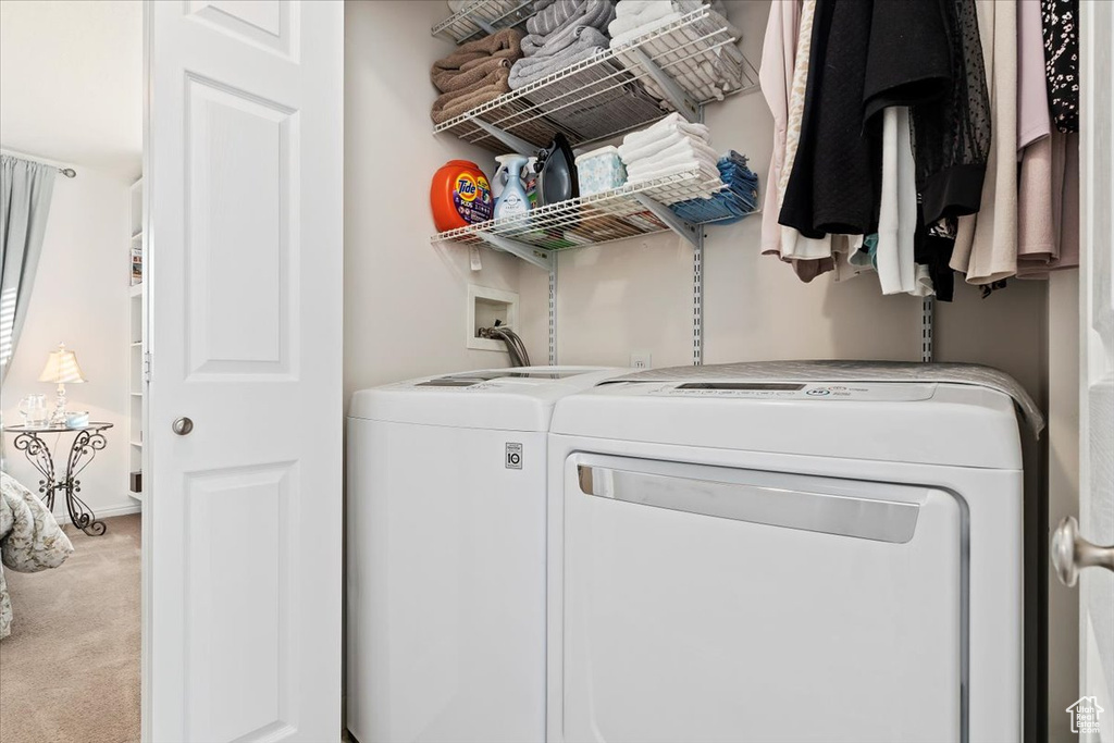 Laundry room featuring light carpet and washing machine and clothes dryer