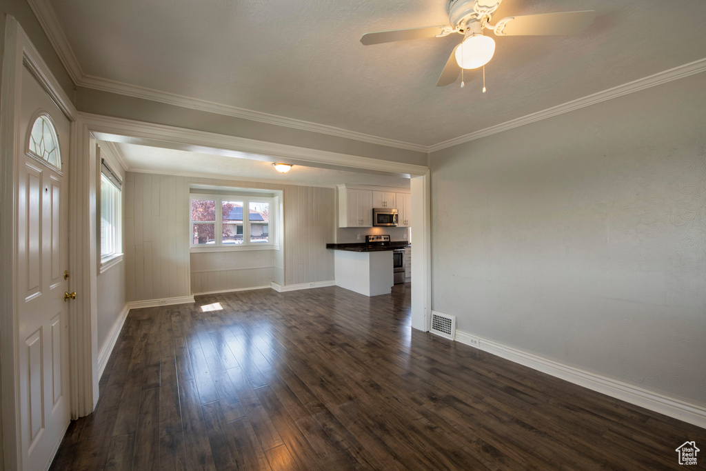 Unfurnished room with dark hardwood / wood-style floors, ceiling fan, and crown molding