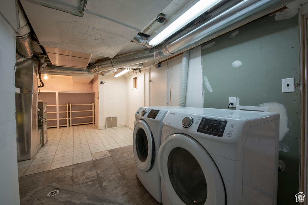Laundry area featuring independent washer and dryer and light tile flooring