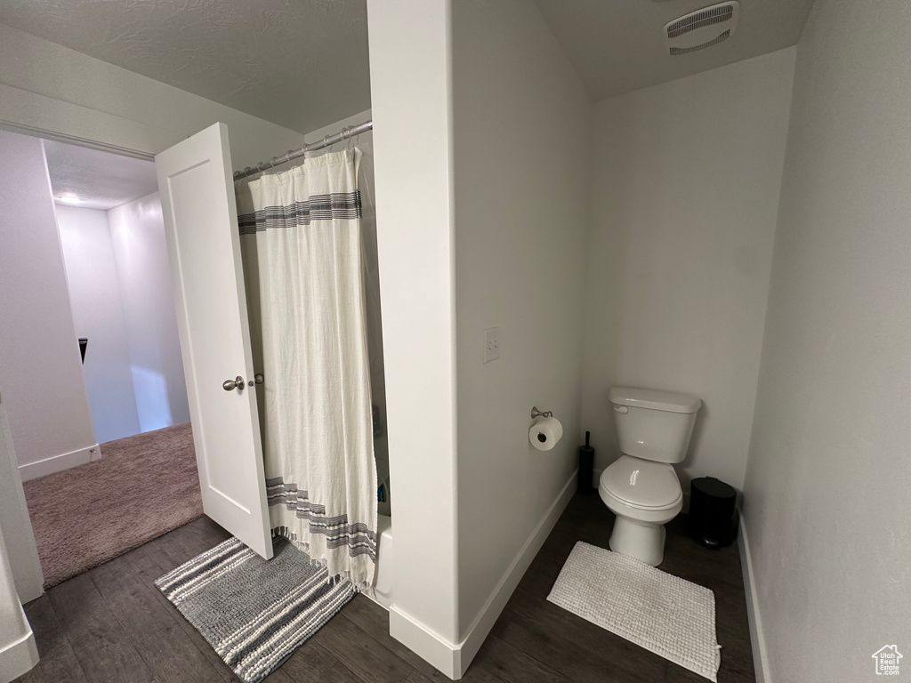 Bathroom with toilet and hardwood / wood-style floors