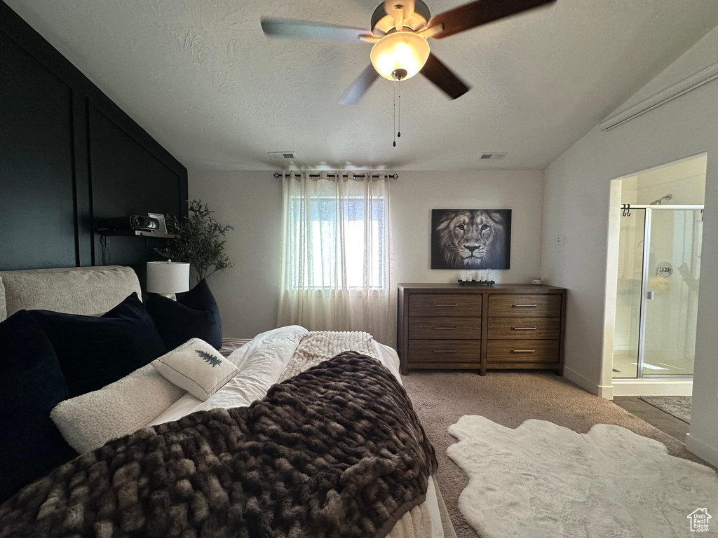 Carpeted bedroom featuring a textured ceiling, ceiling fan, and ensuite bathroom