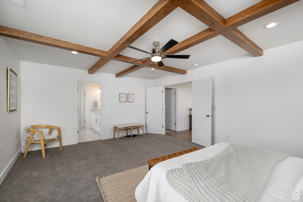 Bedroom featuring ceiling fan, coffered ceiling, beamed ceiling, dark carpet, and connected bathroom
