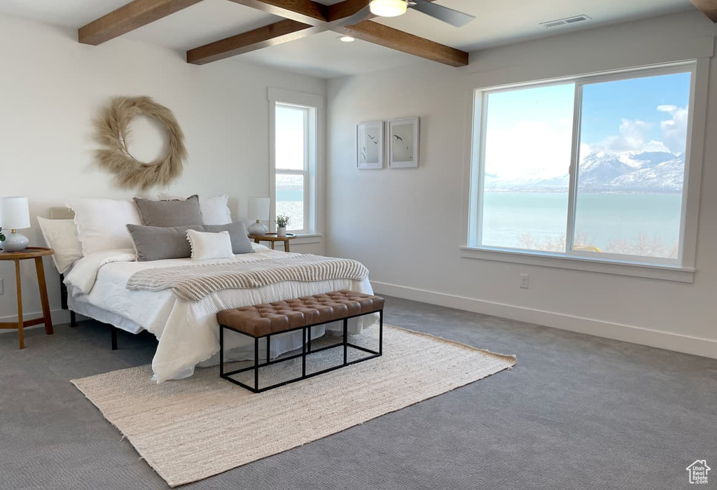 Carpeted bedroom with beam ceiling and ceiling fan