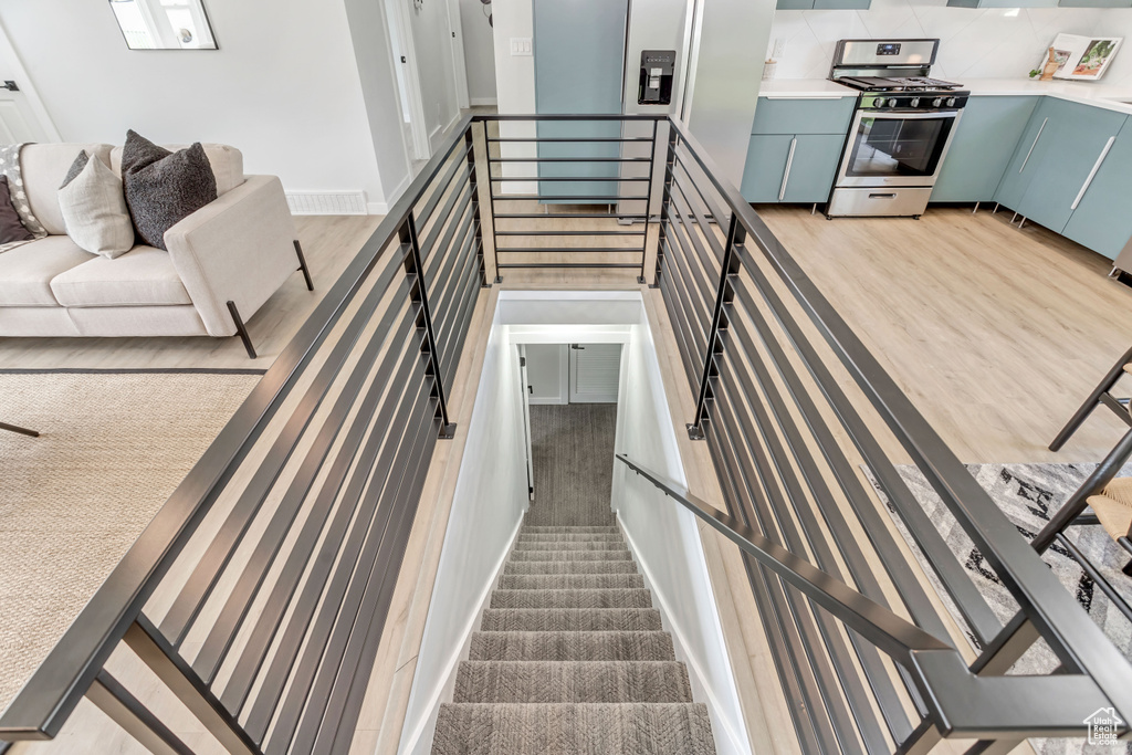 Staircase with light hardwood / wood-style flooring