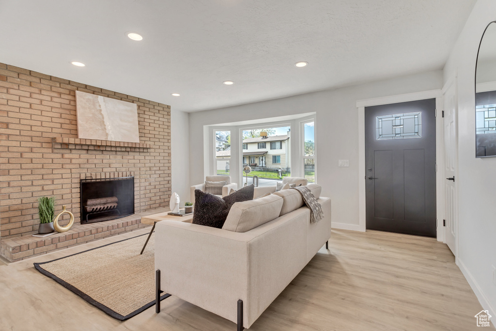 Living room featuring light hardwood / wood-style flooring and a brick fireplace