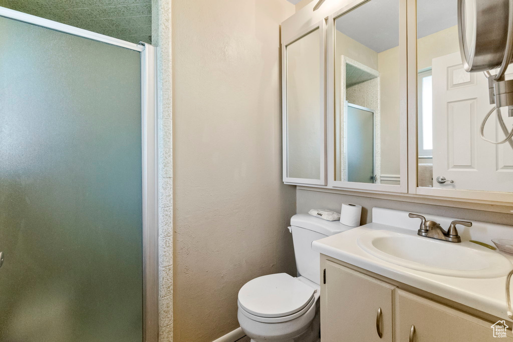 Bathroom featuring walk in shower, oversized vanity, and toilet