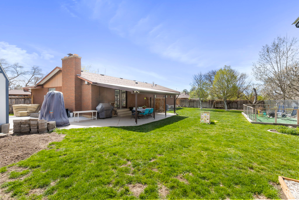 Back of property featuring an outdoor living space, a yard, and a patio area