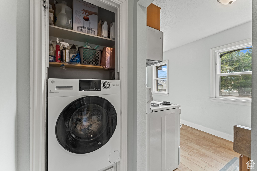 Laundry area featuring light hardwood / wood-style flooring and washer / dryer