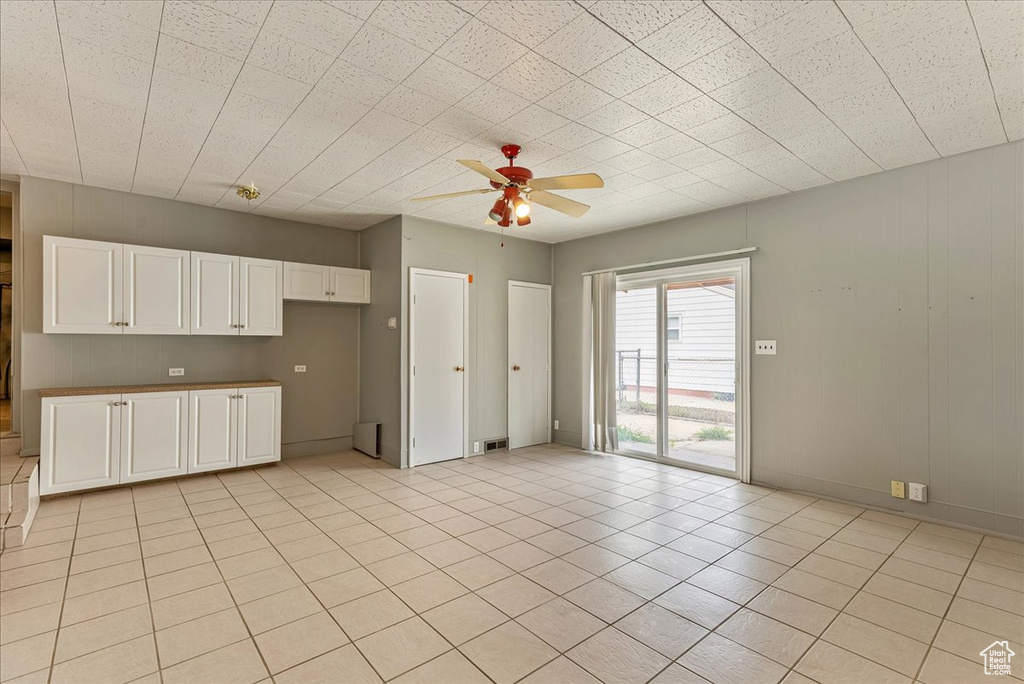 Unfurnished living room featuring ceiling fan and light tile floors