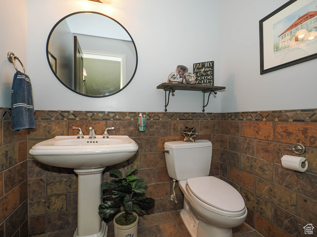 Bathroom featuring tile walls, backsplash, toilet, and tile flooring
