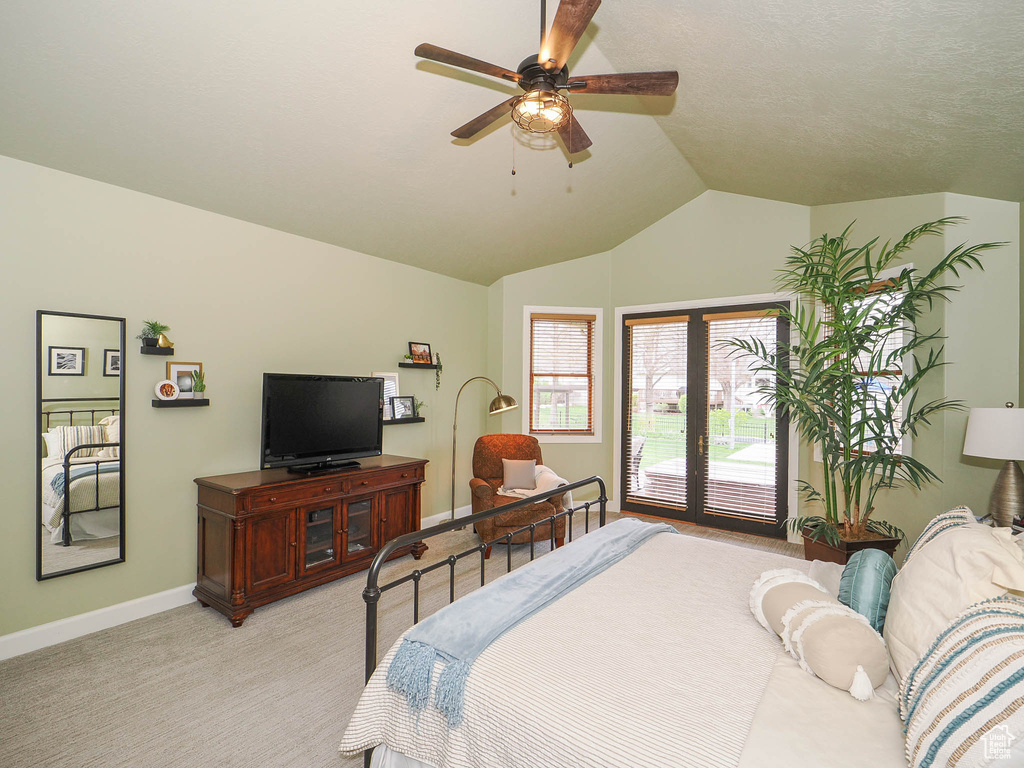 Bedroom with light colored carpet, lofted ceiling, ceiling fan, and access to outside