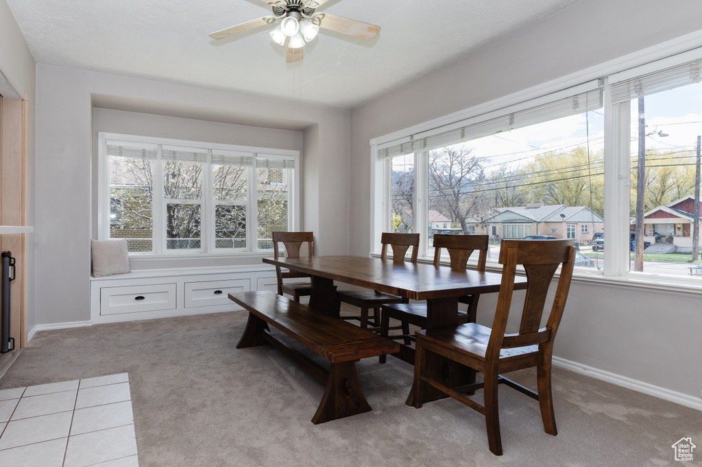 Dining area with light colored carpet and ceiling fan
