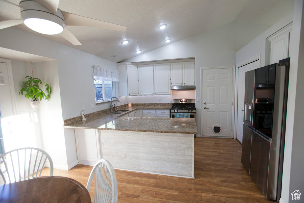 Kitchen with appliances with stainless steel finishes, ceiling fan, white cabinetry, sink, and light wood-type flooring