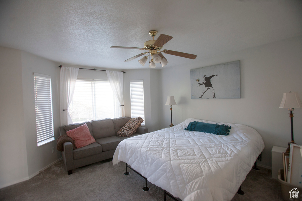 Bedroom with carpet flooring, ceiling fan, and a textured ceiling