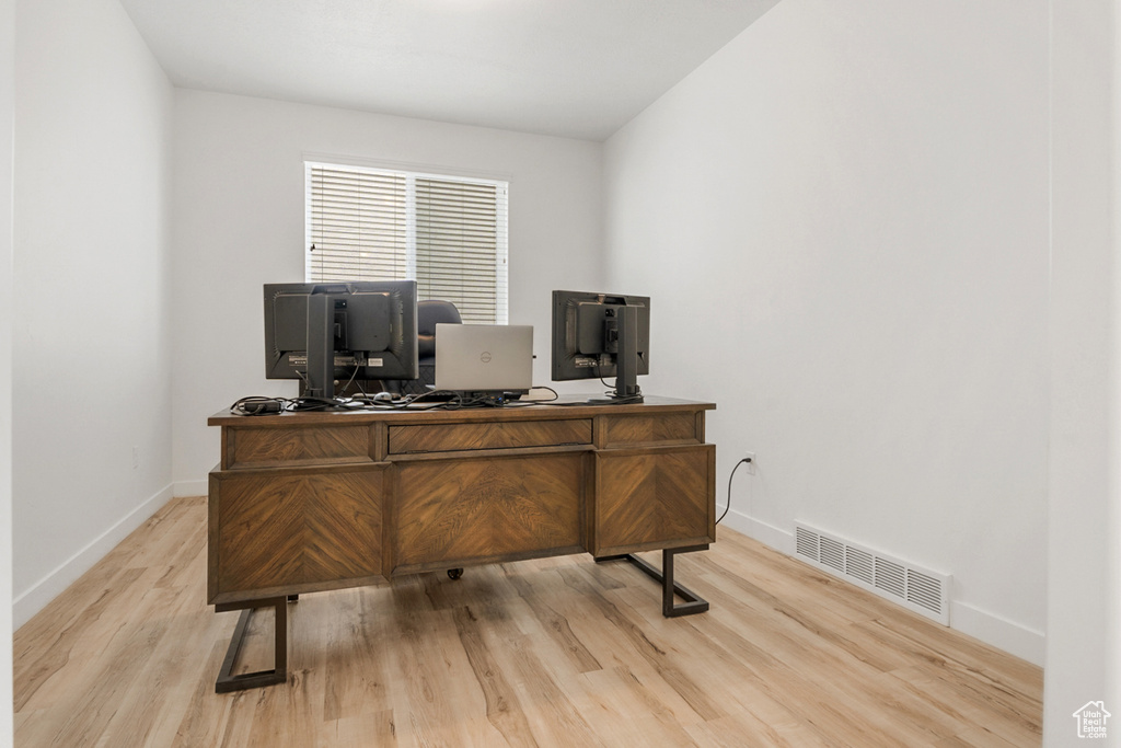 Office with light hardwood / wood-style flooring