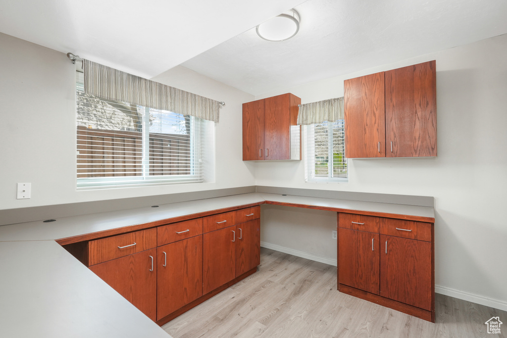 Kitchen with light hardwood / wood-style flooring and built in desk