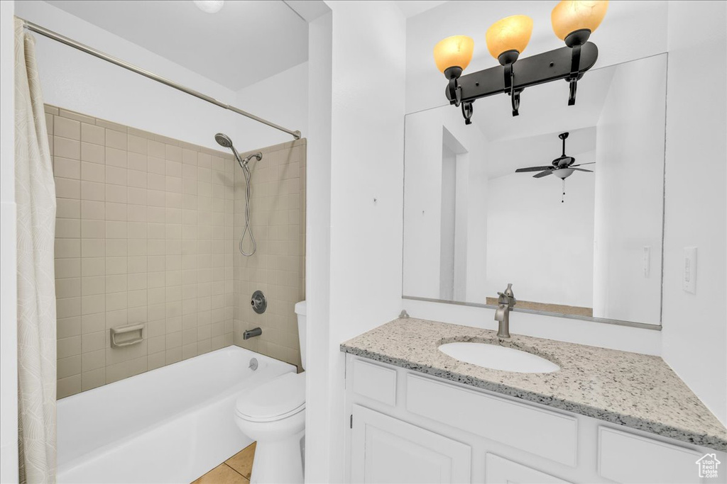 Full bathroom featuring shower / tub combo, tile floors, vanity, toilet, and ceiling fan